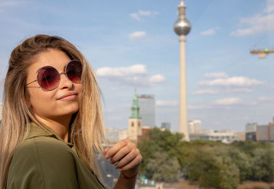Portrait of smiling young woman against berliner fernsehturm