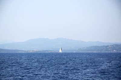 Sailboat in sea against clear sky