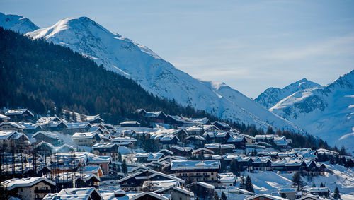 Aerial view of townscape and mountains against sky