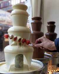 In einen weißen schokobrunnen werden erdbeeren getunkt