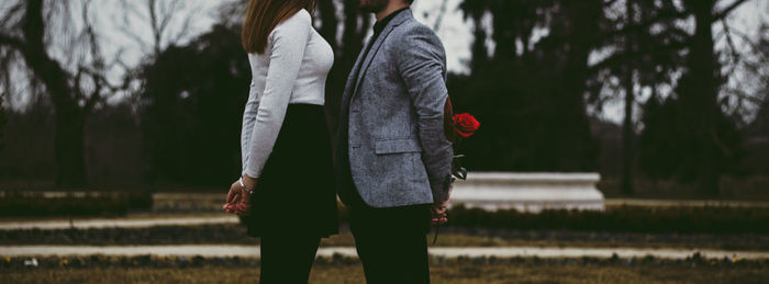 Midsection of couple standing on field