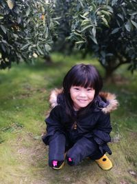 Portrait of smiling girl crouching on field