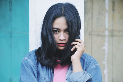 Portrait of confident young woman wearing denim jacket