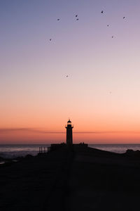 Silhouette of lighthouse against sky during sunset in porto