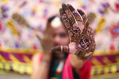 Woman showing henna tattoo during wedding ceremony