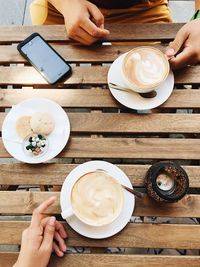 High angle view of woman holding coffee cup on table