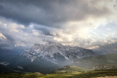 Scenic view of snowcapped mountains against cloudy sky