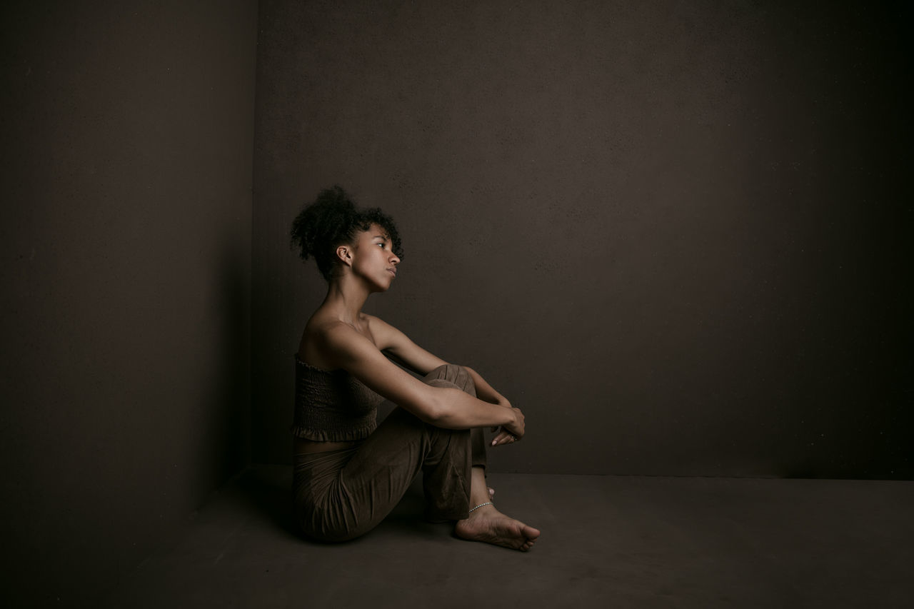 WOMAN SITTING ON WALL