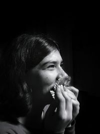 Close-up of teenage girl against black background