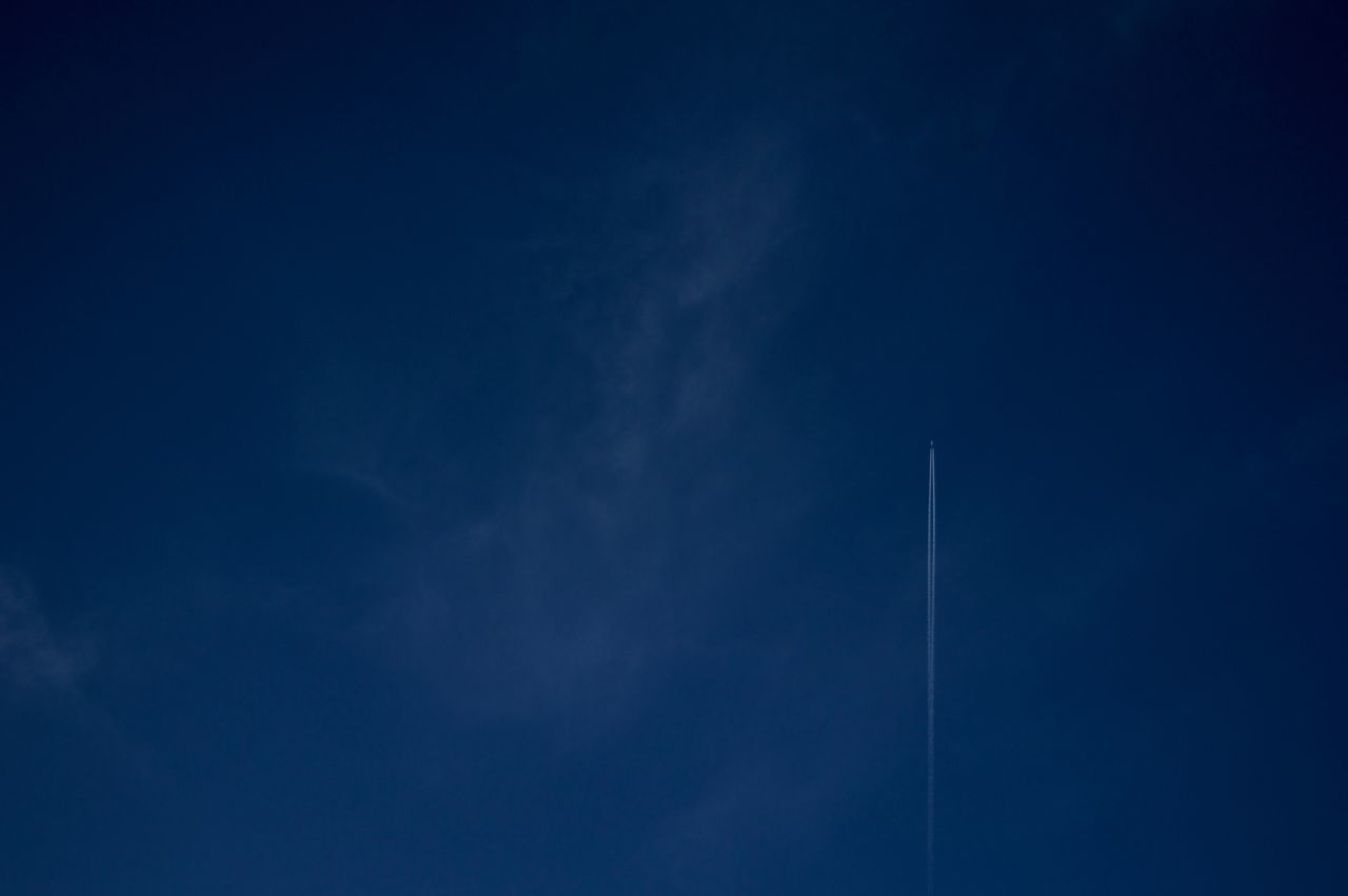 low angle view, blue, sky, tranquility, scenics, sky only, beauty in nature, tranquil scene, nature, cloud, vapor trail, outdoors, dark, full frame, cloudscape, cloud - sky, majestic, high section, no people, dreamlike, dramatic sky, ominous