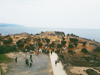 People on beach against clear sky