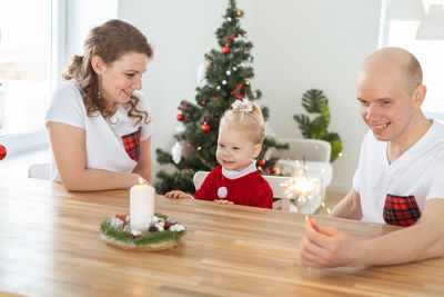 Portrait of smiling family sitting on table