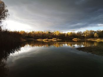 Scenic view of lake against sky at sunset