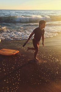 Full length of boy jumping on beach