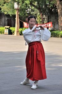 Portrait of smiling girl standing on road in city