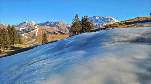 Scenic view of snow mountains against blue sky