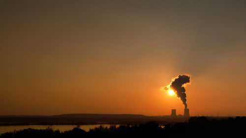 Silhouette man standing on land against sky during sunset