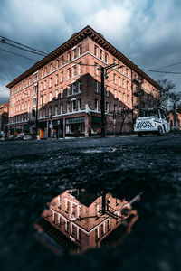 Building by river against sky in city