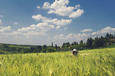 Woman amidst plants on field against sky