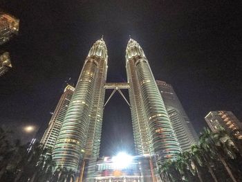 Low angle view of illuminated buildings against sky at night