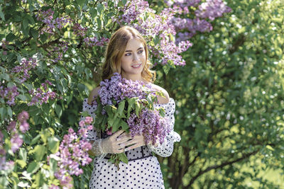 Portrait of a smiling young girl in blooming lilac trees. summer time,vacation.