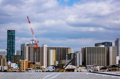 Construction site by buildings against sky