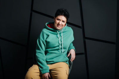 Portrait of smiling boy sitting on wall