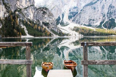 Boats moored on lake against mountain