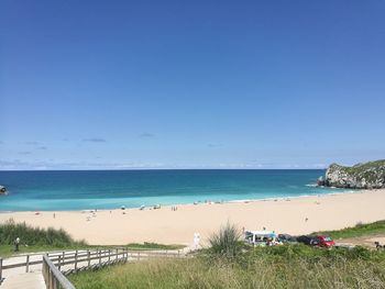 Scenic view of beach against clear blue sky