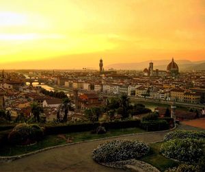 Duomo santa maria del fiore by arno river in cityscape against orange sky