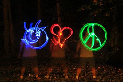 People drawing colorful light paintings