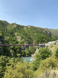 Scenic view of river by mountains against clear sky