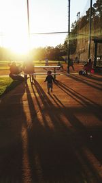 People walking on road at sunset