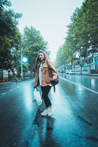 Full length of woman walking in city against sky