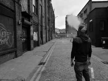 Rear view of man walking on street in city