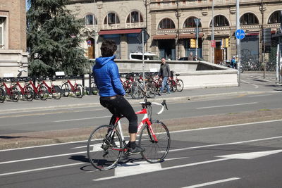 Man riding bicycle on road in city