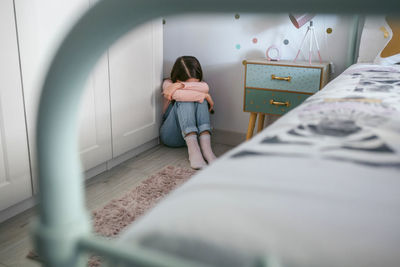 Depressed girl sitting in bedroom