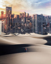 People on modern buildings in city against sky during sunset