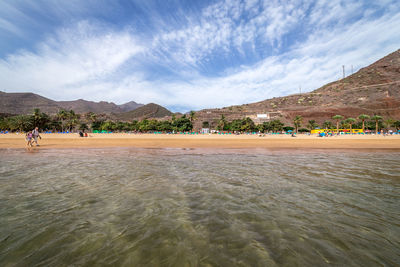 Group of people on beach against sky