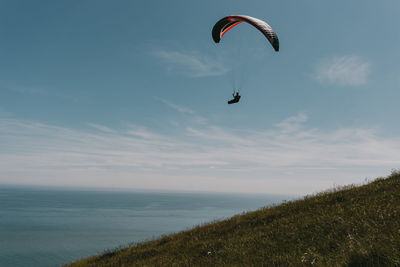 Person paragliding against sky