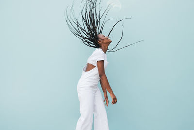 Side view of woman standing against white background