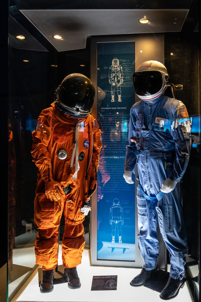 REAR VIEW OF MEN STANDING IN STORE