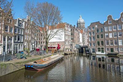 Boats in canal amidst buildings in city