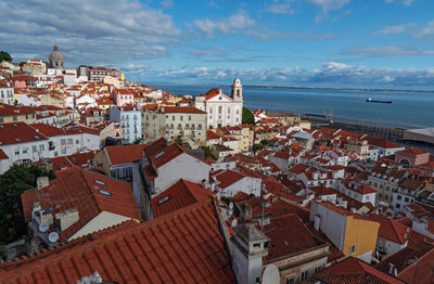 High angle view of townscape by sea against sky