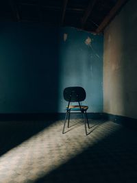 Empty chair against wall at home