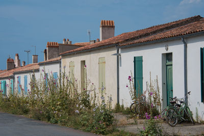 House by street against sky in city