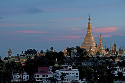 Buildings in city against sky during sunset