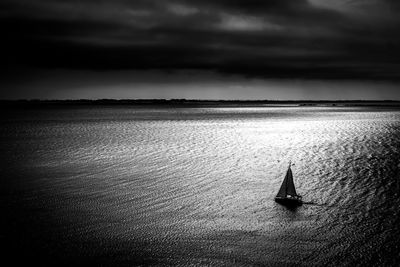 Sailboat sailing on sea against sky