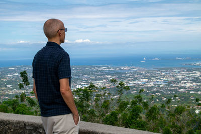 Man looking at city against sky