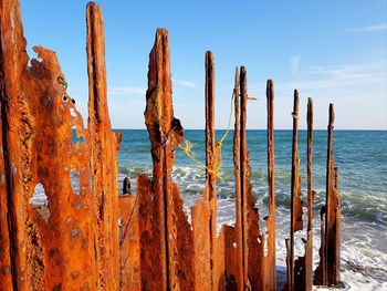 Panoramic view of wooden post on beach against sky